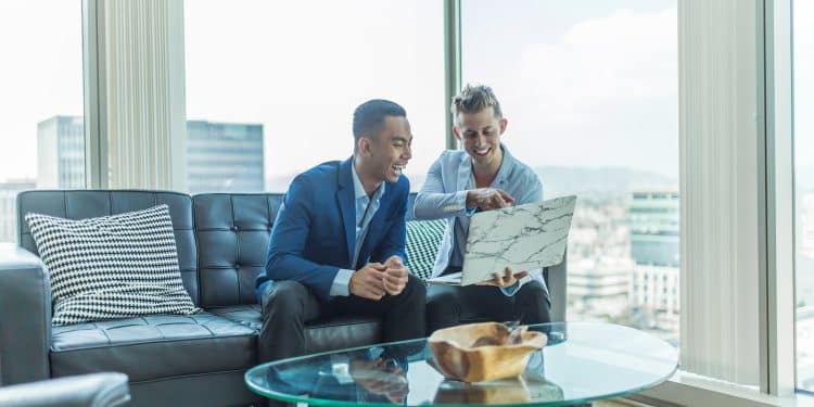 two men in suit sitting on sofa